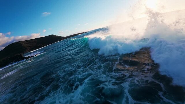 Aerial drone view of Atlantic waves striking volcanic rocks and rugged cliffs on Lanzarote, Canary Islands, near Famara and Los Hervideros, in golden hour light.