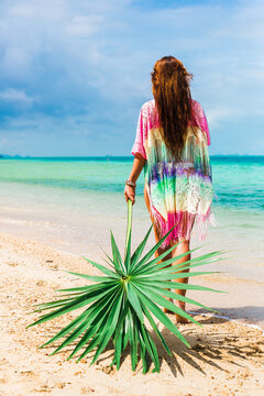 Beautiful lady in a swimsuit and colorful parasol against the background of the sea, on a tropical island, walk on the coast, sitting on a hammock, summer mood