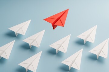 Leading the Flight: A vivid red paper airplane boldly leads a formation of white paper airplanes against a calming blue backdrop, symbolizing leadership and direction.