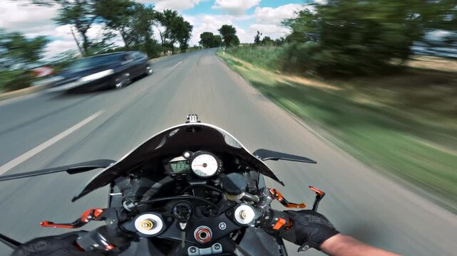 Motorcycle POV riding past trees with light oncoming traffic
