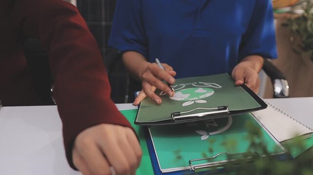 Close up of business people shaking hands over ESG strategic commitment workshop, SDGs report, global warming, green finance investment eco friendly and net zero waste in boardroom training building.