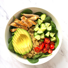 Healthy food bowl with grilled chicken spinach quinoa avocado cucumber and cherry tomatoes