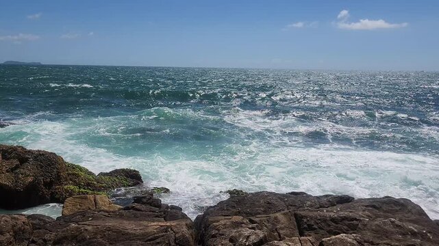 Turquoise Waves and White Sea Foam Crashing on Coastal Rocks