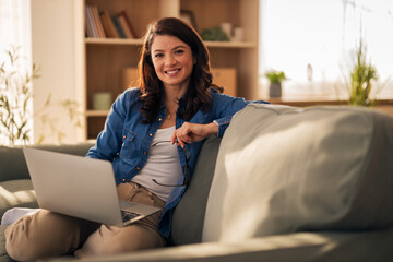 Woman relaxing at home using laptop computer