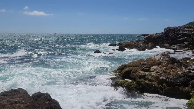 Turquoise Waves and White Sea Foam Crashing on Coastal Rocks