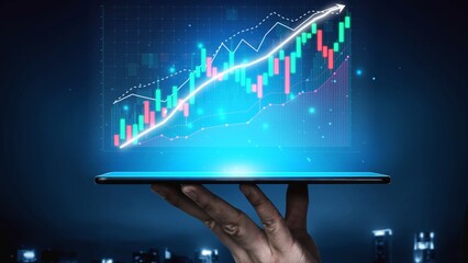 This image showcases a hand holding a tablet that displays a financial chart with a rising trend. It represents growth, investment, and modern technology in a dynamic urban setting. Copula
