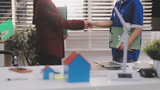 Close up of business people shaking hands over ESG strategic commitment workshop, SDGs report, global warming, green finance investment eco friendly and net zero waste in boardroom training building.