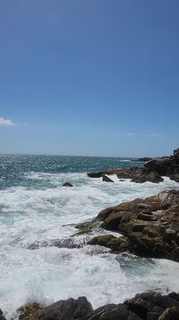 Turquoise Waves and White Sea Foam Crashing on Coastal Rocks