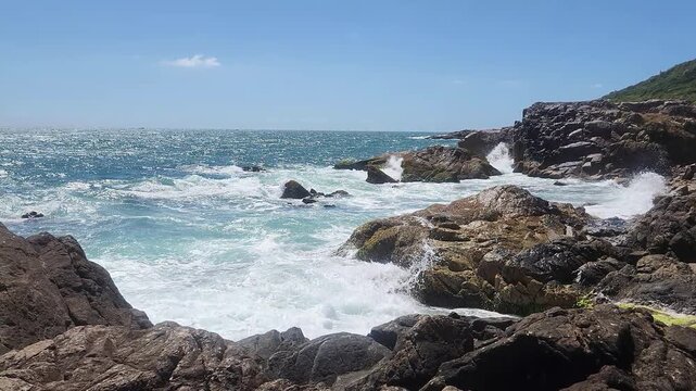 Turquoise Waves and White Sea Foam Crashing on Coastal Rocks