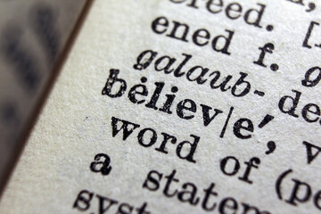 Word believe printed on dictionary page, macro close up
