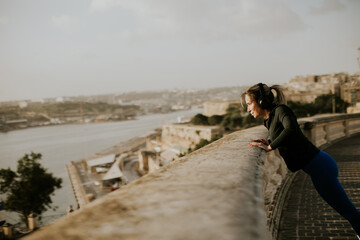 Woman exercises by the water in Malta while enjoying the morning sun and view