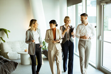 Business team discussing ideas while walking in a modern office space