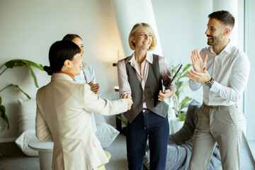 Business team celebrates success in modern office setting during afternoon