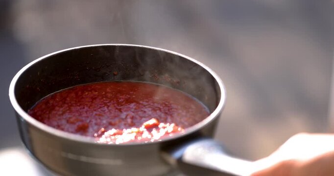Smoking hot tomato sauce in pan in rea time. Sauce for spaghettis and pizzas, Italian style.