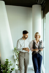 Business professionals discuss ideas while walking in modern office space