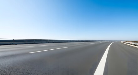 Fototapeta premium A deserted highway stretching into the distance under a clear blue sky