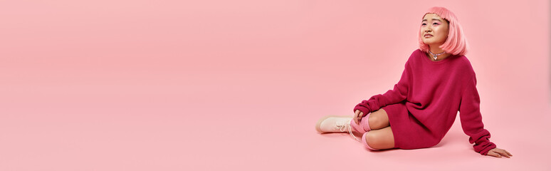 Young woman in vibrant pink sweater relaxes in a whimsical pink space full of charm