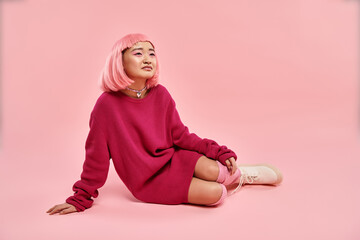 Young woman dressed in vibrant pink fashion expressing joy in a playful setting
