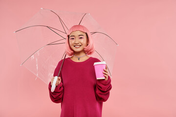 Vibrant young woman embraces joy with a pink umbrella in a playful pink setting