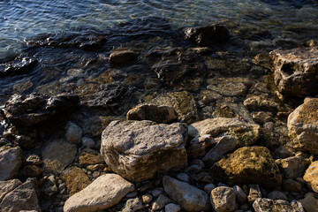 Obraz premium large stones near the seashore in the winter season. a stone beach in an environmentally friendly resort town. concept: tourism and beach recreation 