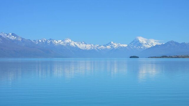 Klarer, ruhiger See vor einer fernen Bergkette unter blauem Himmel, Lake Pukaki Viewpoint, Pukaki, Canterbury, S&uuml;dinsel, Neuseeland, Ozeanien