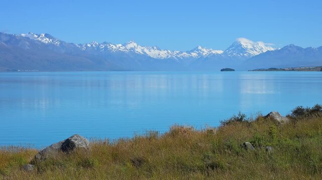 Klarer, ruhiger See vor einer fernen Bergkette unter blauem Himmel, Lake Pukaki Viewpoint, Pukaki, Canterbury, S&uuml;dinsel, Neuseeland, Ozeanien