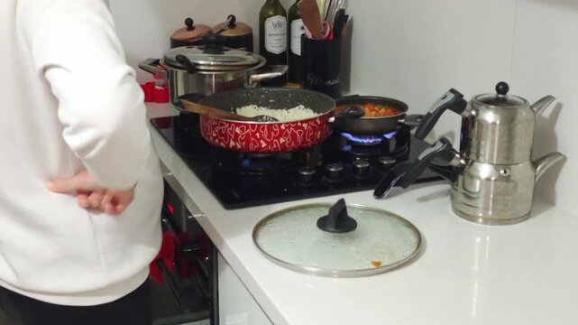Woman cooking traditional chickpea meal on gas stove at home kitchen&rdquo;