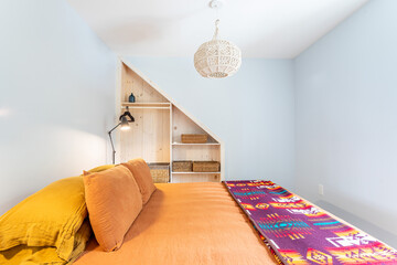 Minimal cozy bedroom interior with built-in storage, warm bedding, and soft natural light