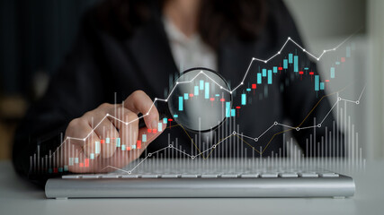 A business professional examines financial data using a magnifying glass over a keyboard, emphasizing accuracy and insight in a modern office environment. Scalp