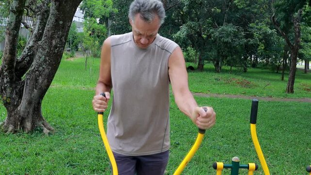 Slow Motion of an Older Man working out at an Outdoor Fitness Gym