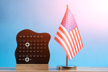 US flag and calendar with November 11 date on blue background for Veterans Day.