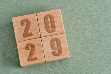 Wooden cubes with numbers 2029 on green background. Concept of future planning and long term goals.
