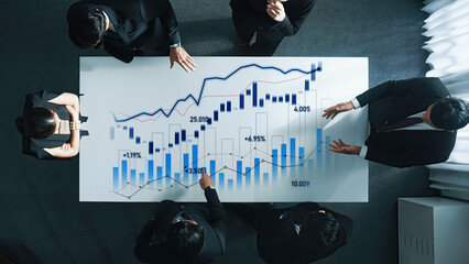 A diverse business team engaged in an analysis session, discussing financial charts and market trends in a modern office environment, promoting teamwork and strategic planning. Scalp