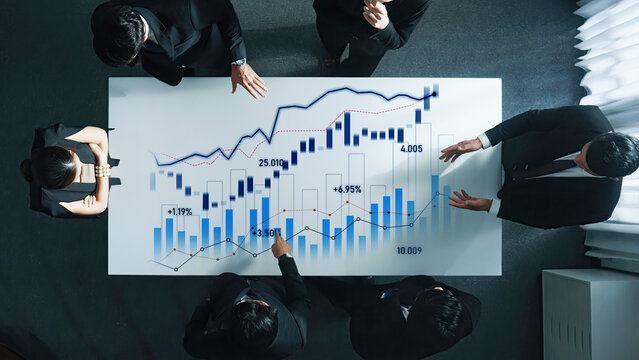 A diverse business team engaged in an analysis session, discussing financial charts and market trends in a modern office environment, promoting teamwork and strategic planning. Scalp - Powered by Adobe
