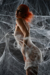 Woman in captivating red attire entangled in a net trap of delicate webs