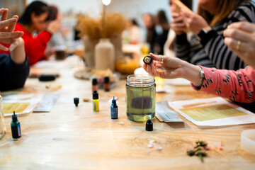 Woman creating handmade scented soy candle during workshop