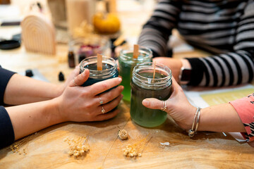 People making handmade soy candles in craft workshop