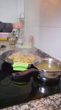 Chef cooking authentic Spanish paella on stove