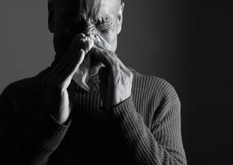flu epidemic cold with blowing nose after catching the flu with gray black background with people stock image stock photo
