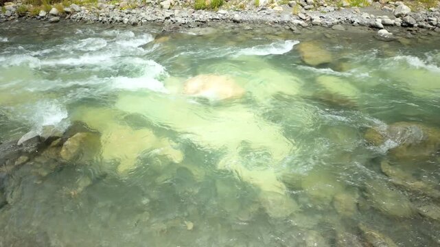 Clear River Flowing Over Submerged Boulders And Pebbles