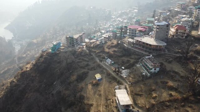 Aerial view of Tosh village nestled in Parvati Valley also cover Panoramic view of Tosh village at sunset, scenic mountains and pine forests in Kullu district, India.