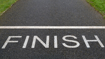 White Finish word painted on a park track. Business success, achievement, and sports competition goal concept. motivation and career path