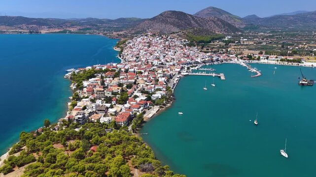 Aerial view of the town and marina of Ermioni, Peloponese, Greece, situates on a peninsula with pine trees during a summer day