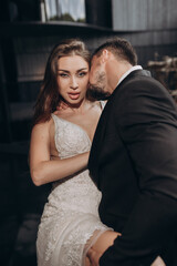 Couple poses in formal attire with a warm embrace at a special event location at night