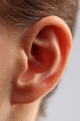 Isolated human ear portrait on white surface with gentle shadows