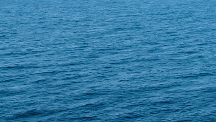 Deep blue water ripples gently across the open ocean on a sunny day