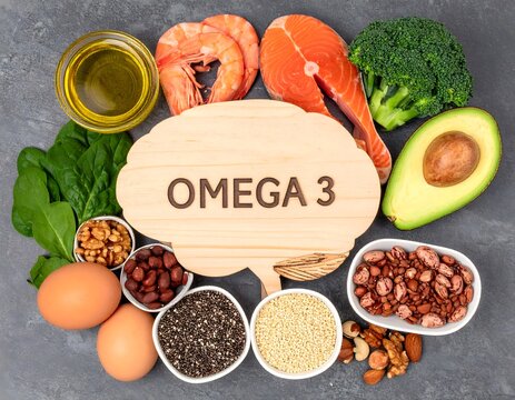 Wooden brain-shaped board with 'OMEGA 3', surrounded by salmon, avocado, spinach, broccoli, nuts, seeds, olive oil and eggs; neutral background, natural lighting, photographic style.