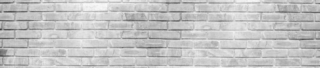 Obraz premium Wide whitewashed brick wall background texture with rough construction details and horizontal brickwork pattern for interior design