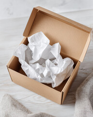 A cardboard box with white tissue paper inside