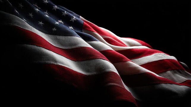 American flag in dramatic studio portrait against a deep black background